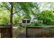 View of the two-car garage and a lush green backyard from the wooden deck at 1029 Katherwood Sw Dr, Atlanta, GA 30310