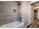 Bathroom features tub with sleek gray wall tiles, a recessed shelf, and a modern shower head at 1029 Katherwood Sw Dr, Atlanta, GA 30310