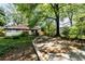A house featuring a long driveway and a well-manicured yard, enhanced by mature trees and lush foliage at 1029 Katherwood Sw Dr, Atlanta, GA 30310