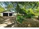 A detached garage with two bays and an expansive driveway surrounded by lush greenery on a sunny day at 1029 Katherwood Sw Dr, Atlanta, GA 30310