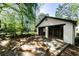 A detached garage with two bays and an expansive driveway surrounded by lush greenery on a sunny day at 1029 Katherwood Sw Dr, Atlanta, GA 30310