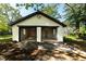 A detached garage with two bays and an expansive driveway surrounded by lush greenery on a sunny day at 1029 Katherwood Sw Dr, Atlanta, GA 30310