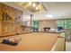 Basement recreation room features wood paneling, a billiards table and an accent brick fireplace at 2080 Old Dominion Rd, Atlanta, GA 30350