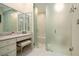 Bathroom showcasing a vanity, seated makeup area, and glass-enclosed shower offering a clean and modern design at 2080 Old Dominion Rd, Atlanta, GA 30350