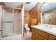 Full bathroom with glass shower doors, wooden vanity, and patterned wallpaper at 2080 Old Dominion Rd, Atlanta, GA 30350