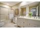Well-lit bathroom featuring double sinks, a shower, and classic cabinetry at 2080 Old Dominion Rd, Atlanta, GA 30350