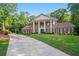 Brick home with large lawn, columned entryway, mature trees and a long driveway at 2080 Old Dominion Rd, Atlanta, GA 30350