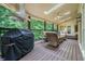 Covered outdoor living space featuring a grill, comfortable seating, and wooded views at 2080 Old Dominion Rd, Atlanta, GA 30350