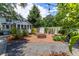 Private backyard with a brick fire pit, stone pathways, and lush greenery, perfect for relaxing and entertaining at 253 Pine Valley Dr, Powder Springs, GA 30127