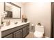 Bathroom featuring a gray vanity and toilet, with a light colored tile floor and neutral walls at 253 Pine Valley Dr, Powder Springs, GA 30127