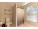 Bathroom featuring a toilet and shower with a neutral curtain and a window with blinds at 253 Pine Valley Dr, Powder Springs, GA 30127