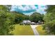 Beautiful white farmhouse with a large lawn, mature trees, and circular driveway at 253 Pine Valley Dr, Powder Springs, GA 30127