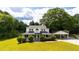 Charming two-story home featuring a welcoming front porch, a carport, and mature trees surrounding the property at 253 Pine Valley Dr, Powder Springs, GA 30127