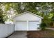 Two-car garage offers ample parking with a white picket fence and a well-maintained exterior at 253 Pine Valley Dr, Powder Springs, GA 30127