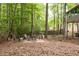 Relaxing backyard with a stone patio, fire pit, and seating area among mature trees at 3573 Bramwell Nw Xing, Kennesaw, GA 30144