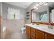 Bathroom featuring a double vanity, decorative mirror, shelves, and tile floor at 3573 Bramwell Nw Xing, Kennesaw, GA 30144