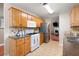 Traditional kitchen features wood cabinets, tile floors, stainless steel refrigerator, and view into the living room at 3573 Bramwell Nw Xing, Kennesaw, GA 30144