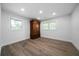 Bright bedroom with hardwood floors, two windows, and a classic wardrobe providing ample storage space at 3904 Bakers Ferry Sw Rd, Atlanta, GA 30331