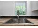 Stainless steel sink with stylish faucet sits beneath a window offering natural light and a view of the outdoors at 3904 Bakers Ferry Sw Rd, Atlanta, GA 30331