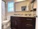 Well-lit bathroom showcasing granite countertops, a dark wood vanity, and a decorative mirror at 7460 Highway 101 N, Rockmart, GA 30153