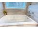White soaking tub with jets, and window with tiled surround at 7460 Highway 101 N, Rockmart, GA 30153