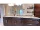 Bathroom featuring granite countertops, dark wood cabinets, and large mirror at 7460 Highway 101 N, Rockmart, GA 30153
