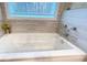 Bathtub area features a jetted tub, gray tile, and a privacy window at 7460 Highway 101 N, Rockmart, GA 30153