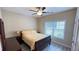 Cozy bedroom features a ceiling fan, a large window, neutral decor, and comfortable furnishings at 7460 Highway 101 N, Rockmart, GA 30153
