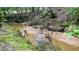 Close-up of the creek featuring a rocky bank, moss accents, and clear flowing water at 7460 Highway 101 N, Rockmart, GA 30153