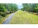 Long driveway leads to a beautiful home surrounded by lush greenery and mature trees at 7460 Highway 101 N, Rockmart, GA 30153