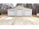 Three car garage with concrete driveway and trees in the background at 7460 Highway 101 N, Rockmart, GA 30153