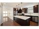 Modern kitchen with stainless steel appliances, dark wood cabinets, a large island, and hardwood floors at 1202 Laurel Cliff Se Dr, Smyrna, GA 30082