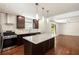 Open kitchen with stainless steel appliances, dark wood cabinets, a large island, and hardwood floors at 1202 Laurel Cliff Se Dr, Smyrna, GA 30082