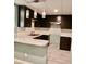 Well-lit kitchen featuring dark cabinets, marble countertops, and stylish pendant lighting at 1202 Laurel Cliff Se Dr, Smyrna, GA 30082