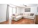Bright living room features hardwood floors, ceiling fan, a comfortable sectional couch, and large windows at 1202 Laurel Cliff Se Dr, Smyrna, GA 30082