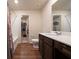 Bathroom with wood-look flooring, wooden vanity, framed mirror, and shower-tub combo at 3530 Ridge Hill Pkwy, Douglasville, GA 30135