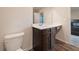 Bright bathroom features a dark wood vanity, toilet, and tile flooring; and it looks into the Primary bedroom at 3530 Ridge Hill Pkwy, Douglasville, GA 30135