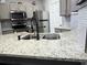 Close-up of a kitchen with stainless steel appliances, granite counters, and a modern faucet at 5641 Roswell Rd # 111, Sandy Springs, GA 30342