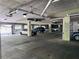 Well-lit parking garage with assigned spots, security gate, visible piping, and painted concrete at 5641 Roswell Rd # 111, Sandy Springs, GA 30342