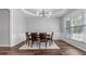 Elegant dining room with a modern chandelier, tray ceiling, and dark wood flooring at 3525 Elder Field Ln, Cumming, GA 30040