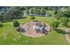 Aerial shot of community playground with swings and slides surrounded by a mulch base, benches and a grassy park at 3525 Elder Field Ln, Cumming, GA 30040