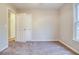 Cozy bedroom showcasing neutral walls, plush carpet, a large window, and a closet door for ample storage at 402 Hancock Ct, Woodstock, GA 30188