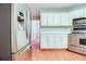 Kitchen showcases stainless steel appliances, white cabinets, and an island with bar seating at 402 Hancock Ct, Woodstock, GA 30188