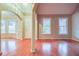 Open-concept living room featuring hardwood floors, arched entryway, and large windows at 402 Hancock Ct, Woodstock, GA 30188