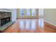 Open-concept living room features hardwood floors, stone fireplace, and many windows at 402 Hancock Ct, Woodstock, GA 30188