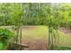 Lush backyard featuring an arched trellis and a serene grassy expanse at 4171 Whispering Forest Sw Ct, Lilburn, GA 30047