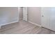 Bedroom featuring light wood-look flooring, neutral walls, and white doors at 4171 Whispering Forest Sw Ct, Lilburn, GA 30047