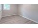 This bedroom features wood-look floors, a bright window, and neutral walls, offering a cozy space at 4171 Whispering Forest Sw Ct, Lilburn, GA 30047