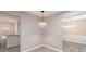 Neutral dining area with light wood-look floors and modern light fixtures at 4171 Whispering Forest Sw Ct, Lilburn, GA 30047