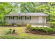 Exterior view of a charming single-story home with a wooden deck and lush landscaping at 4171 Whispering Forest Sw Ct, Lilburn, GA 30047